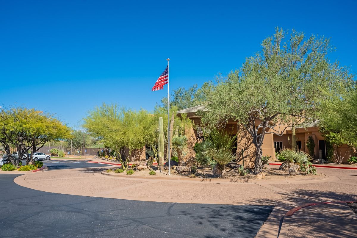 Community building with an American flag and desert landscaping at Legend Trail in North Scottsdale