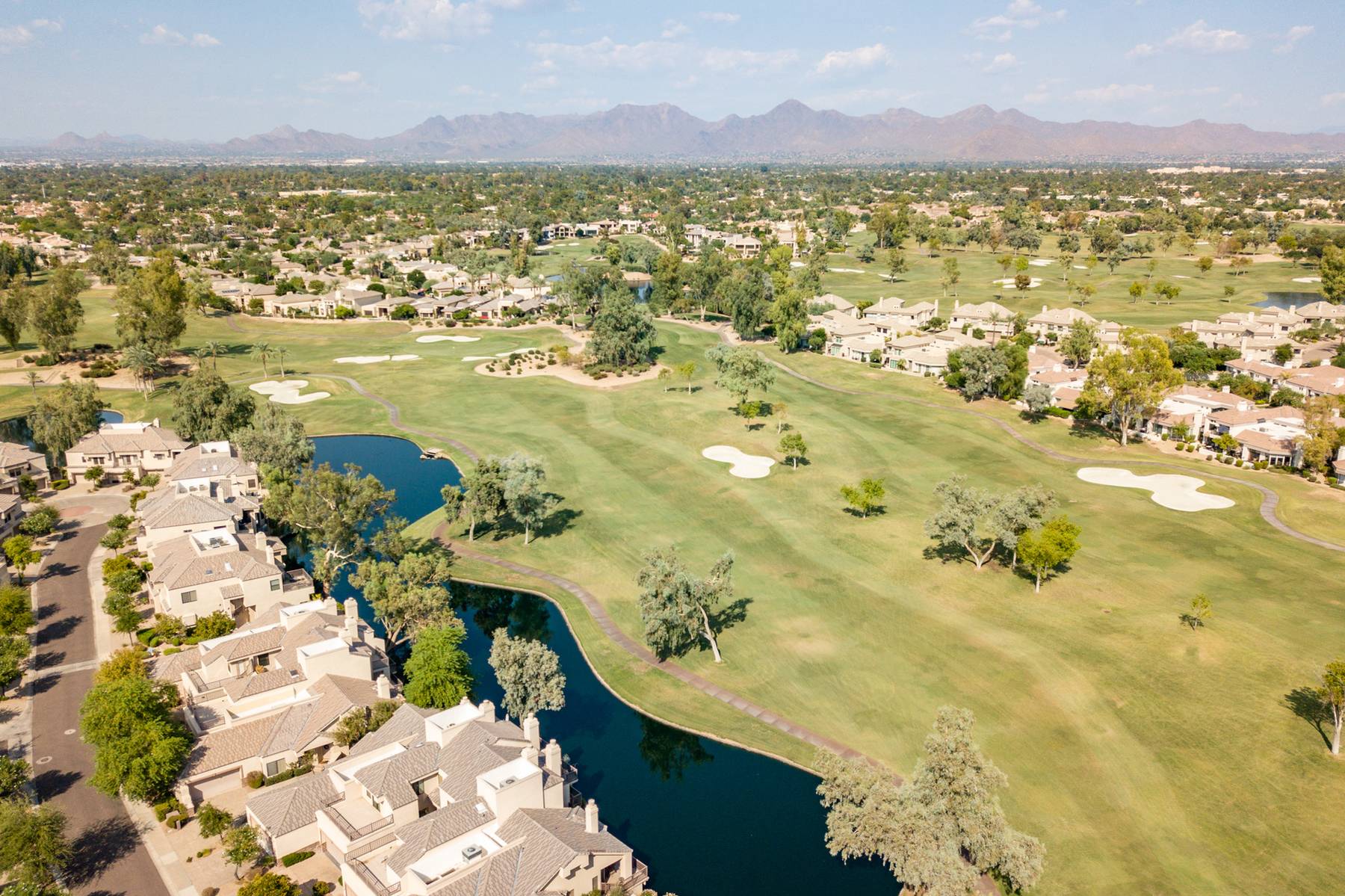 Aerial view of Gainey Ranch golf course, lakes and homes with mountains on the horizon, Scottsdale