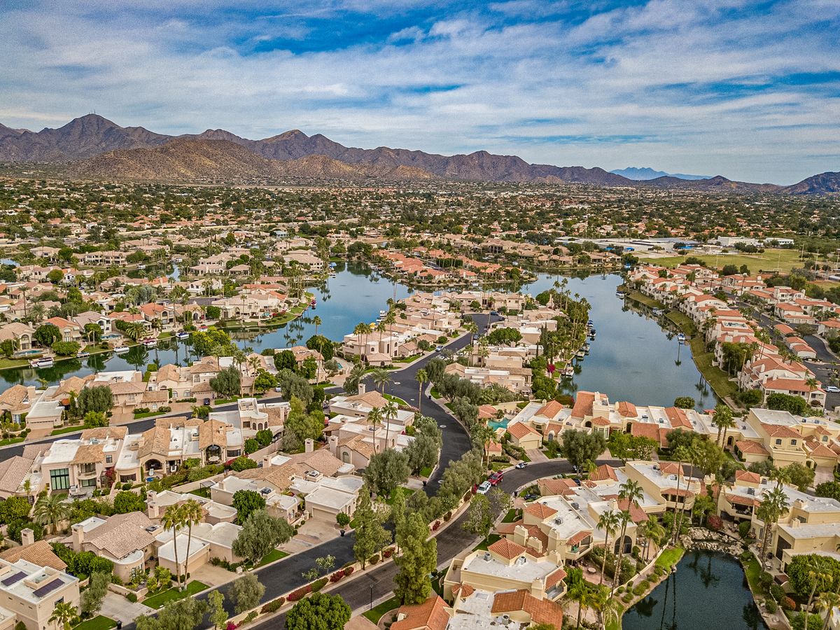 Aerial view of Scottsdale Ranch neighborhoods and lake with mountains beyond