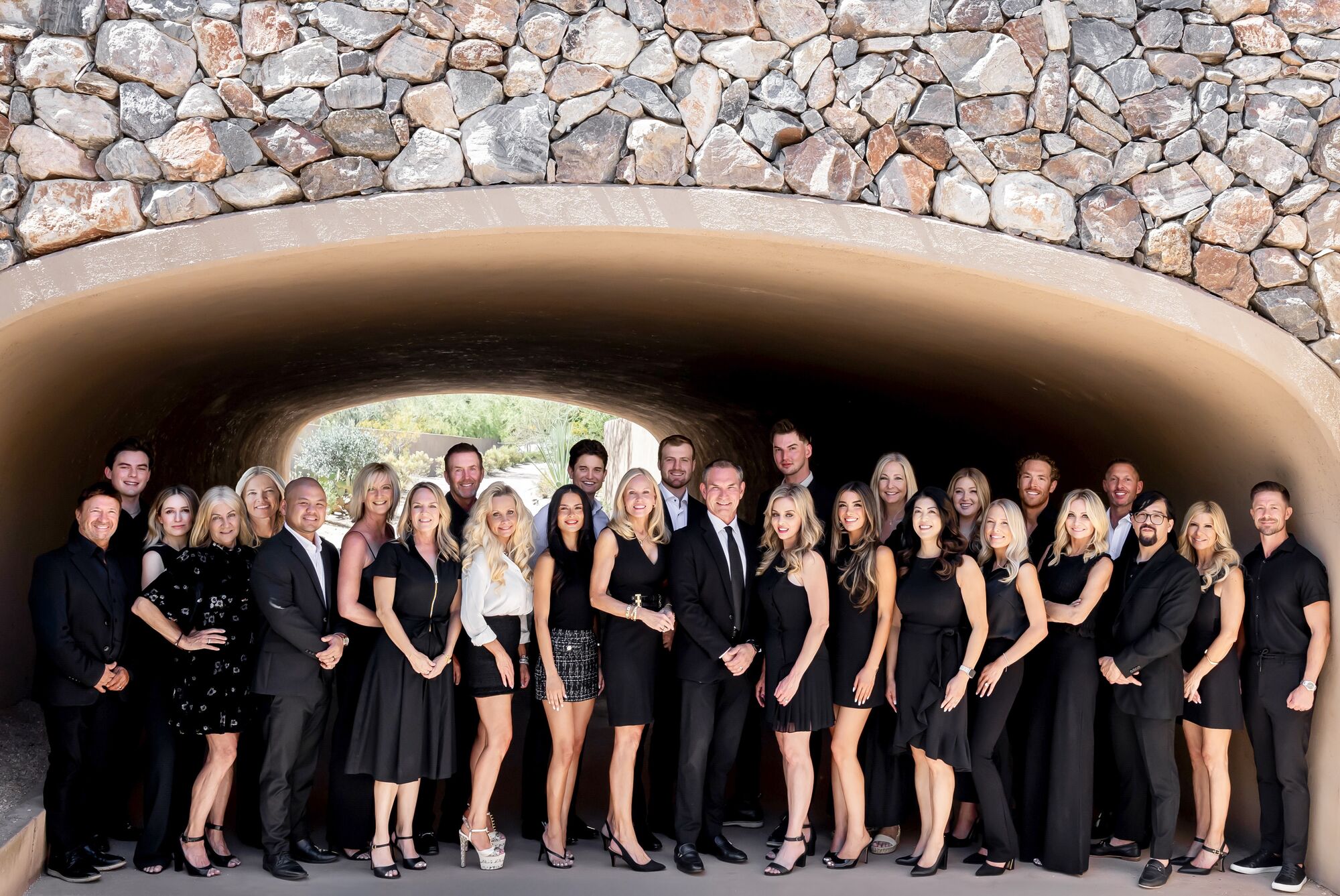 The Tackett Team gathered beneath a stone archway in Scottsdale